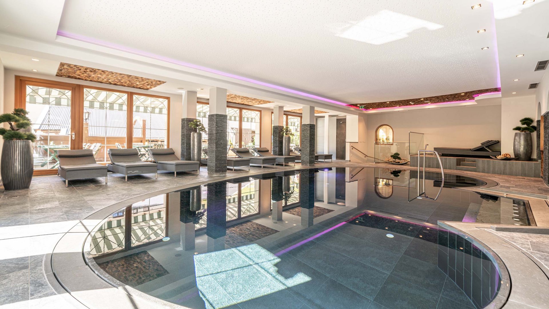 Saunadörfl und Bergsee in Ihrem Hotel in Tirol mit Pool Innenbereich mit modernem Hallenbad und Liegestühlen am Fenster