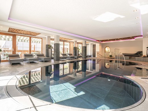 Saunadörfl und Bergsee in Ihrem Hotel in Tirol mit Pool Innenbereich mit modernem Hallenbad und Liegestühlen am Fenster