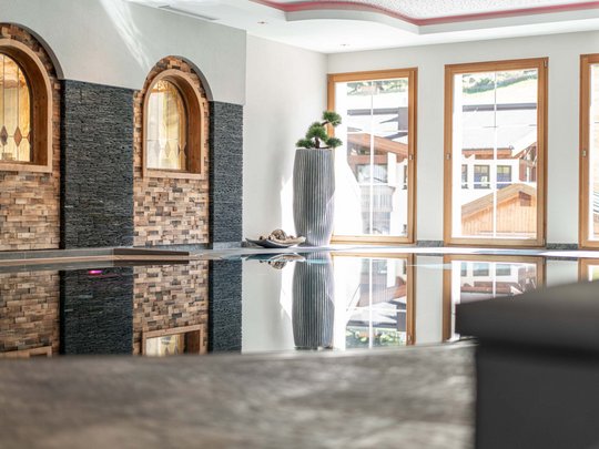 Saunadörfl und Bergsee in Ihrem Hotel in Tirol mit Pool Innenpool mit großen Fenstern und dekorativen Wandverzierungen