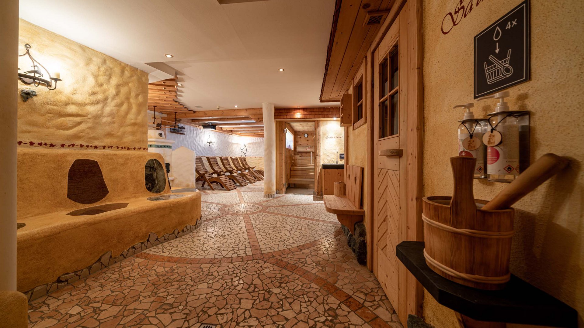 Saunadörfl und Bergsee in Ihrem Hotel in Tirol mit Pool Innenansicht eines Wellnessbereichs mit Saunaraum und Liegestühlen