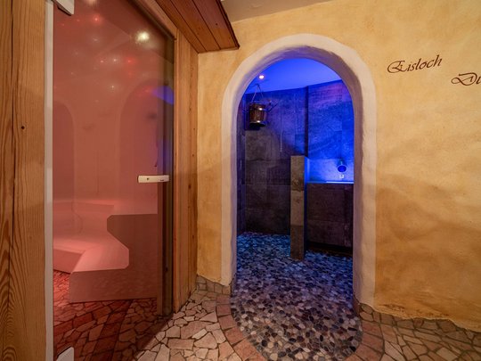 Saunadörfl und Bergsee in Ihrem Hotel in Tirol mit Pool Eingang zu Sauna und Duschbereich mit blauem Licht