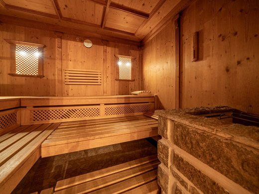 Saunadörfl und Bergsee in Ihrem Hotel in Tirol mit Pool Innenansicht einer Holzsauna mit Bänken und Steinofen