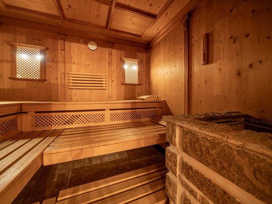 Saunadörfl und Bergsee in Ihrem Hotel in Tirol mit Pool Innenansicht einer Holzsauna mit Bänken und Steinofen
