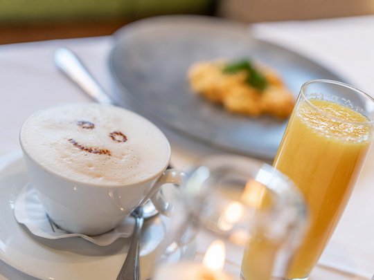 Lieu de rêve Vent : notre hôtel dans l’Ötztal Café avec visage souriant en mousse de lait, jus d'orange et collation