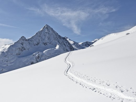 Spend a fantastic winter holiday in Tyrol. Snow-covered mountain peak with tracks in fresh snow