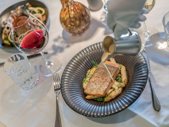 The heights of indulgence in Vent: our restaurant, Die Post Salmon fillet with asparagus and sauce on black plate, red wine in glass