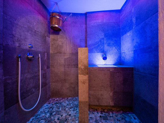 Lieu de rêve Vent : notre hôtel dans l’Ötztal Cabine de douche moderne avec éclairage bleu et seau en bois suspendu