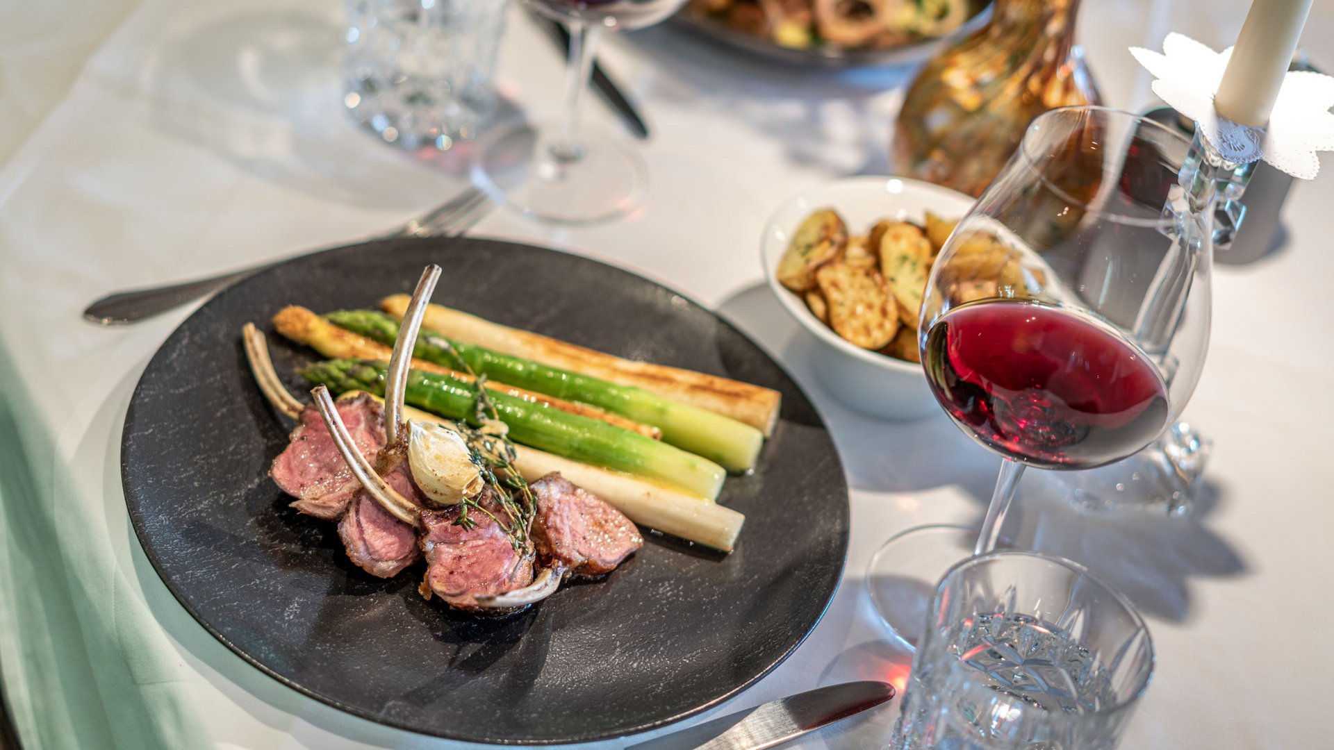 The heights of indulgence in Vent: our restaurant, Die Post Lamb chops with green and white asparagus, potatoes and red wine on set table