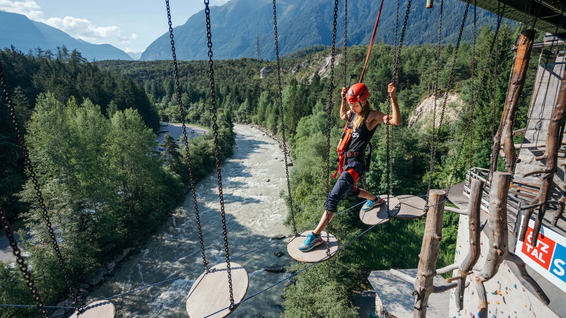 Ötztal Summer Card : découvrir l’Ötztal depuis votre hôtel Femme grimpant sécurisée sur des plateformes suspendues dans un parc d'escalade au-dessus d'une rivière