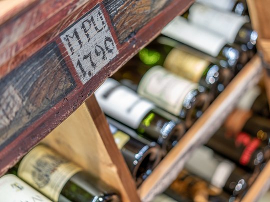 The heights of indulgence in Vent: our restaurant, Die Post Wine bottles in an old wooden labeled wine rack