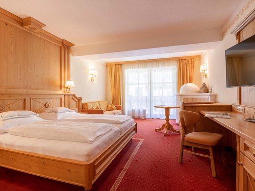 L’hôtel de bien-être dans l’Ötztal : du calme bienfaisant Chambre d'hôtel lumineuse avec deux lits, canapé, bureau et balcon