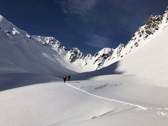 Backcountry skiing near Vent: start directly from our hotel Two skiers in snowy valley under blue sky