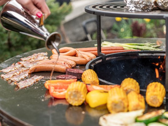 The heights of indulgence in Vent: our restaurant, Die Post Grilling vegetables and sausages on a round outdoor grill