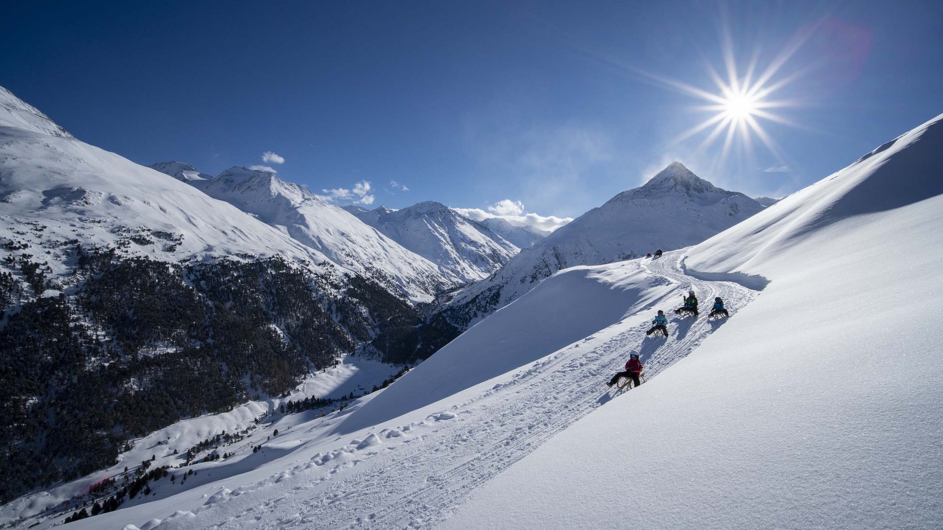 Winterwandern, Langlaufen und Rodeln in Vent Kinder rodeln auf verschneitem Berghang unter strahlendem Sonnenschein