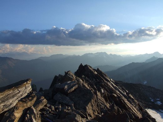 Sehnsuchtsort Vent: unser Hotel im Ötztal Felsiger Berggipfel mit Wolken und entfernten Bergketten bei Sonnenuntergang
