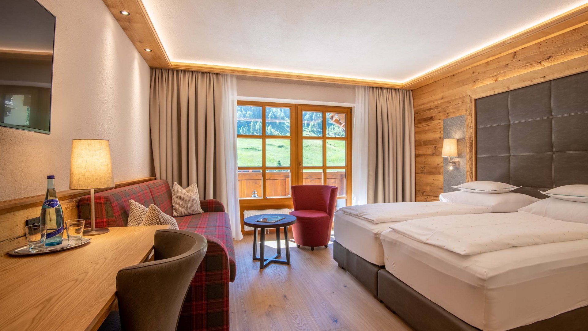 Familienhotel in Vent Gemütliches Hotelzimmer mit Doppelbett, Sitzbereich und Bergblick