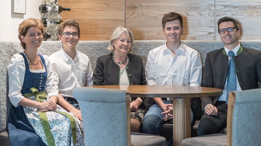 Was uns antreibt Fünf Menschen sitzen an einem Holztisch in einer gemütlichen Umgebung