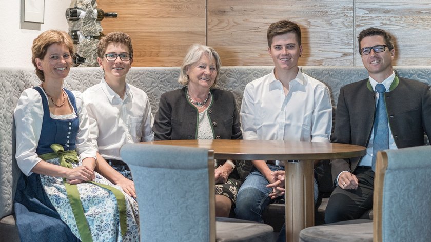 Ce qui nous motive Cinq personnes assises autour d'une table en bois dans un cadre chaleureux