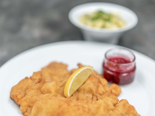 The heights of indulgence in Vent: our restaurant, Die Post Wiener schnitzel with lemon slice, lingonberry sauce, and potato salad