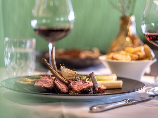 The heights of indulgence in Vent: our restaurant, Die Post Lamb chops with vegetables and red wine glass at a restaurant