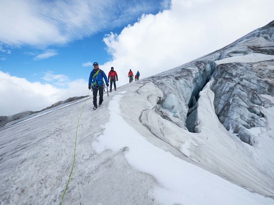 Sur le Similaun et la Wildspitze de notre hôtel à Vent Groupe d'alpinistes en cordée sur un sommet glacé