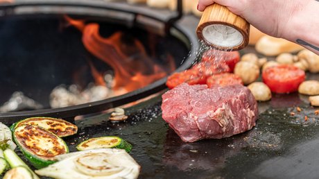 Pictures of our mountain hotel in Vent Raw steak and vegetables on grill with hand sprinkling salt