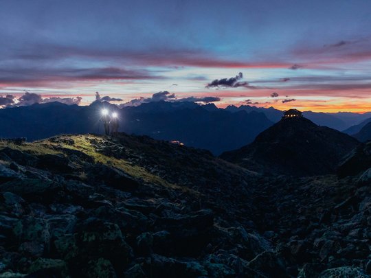 Wandern in den Ötztaler Alpen: von Ihrem Hotel in die Berge Zwei Wanderer mit Stirnlampen bei Sonnenuntergang in den Bergen