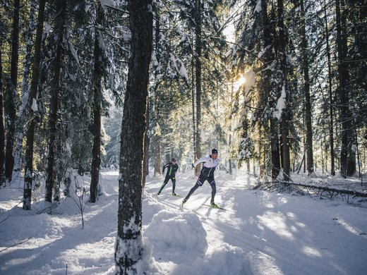 Winterwandern, Langlaufen und Rodeln in Vent Zwei Langläufer im verschneiten Wald bei Sonne