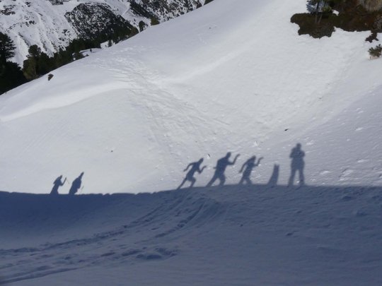 Von Ihrem Hotel zum Schneeschuh- und Winterwandern in Vent Schatten von fünf Menschen auf schneebedecktem Berghang