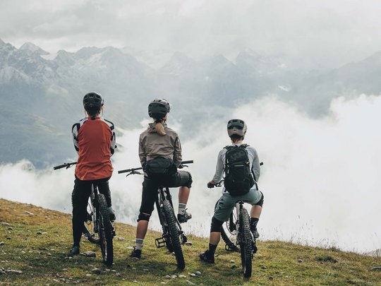 Natur- und Alpinhotel Post: Sehenswürdigkeiten im Ötztal Drei Radfahrer in Schutzhelmen blicken auf neblige Berglandschaft