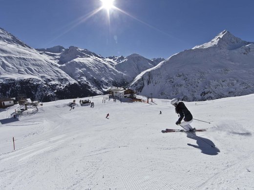 Ein erlebnisreicher Skiurlaub in Vent Skifahrer auf sonniger Piste mit schneebedeckten Bergen und Hütte im Hintergrund