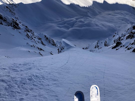 Backcountry skiing near Vent: start directly from our hotel View from skis down a steep snowy mountain slope in the Alps.
