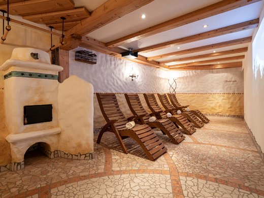 L’hôtel de bien-être dans l’Ötztal : du calme bienfaisant Salle de repos avec chaises en bois et poêle traditionnel