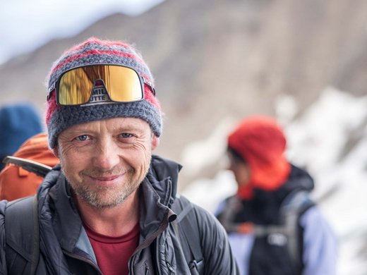 Sur le Similaun et la Wildspitze de notre hôtel à Vent Homme souriant en tenue de montagne avec bonnet et lunettes, paysage montagneux en arrière-plan