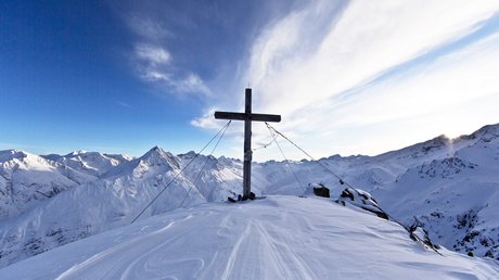 Des impressions de notre hôtel alpin à Vent ! Croix en bois au sommet enneigé avec panorama montagneux et ciel nuageux