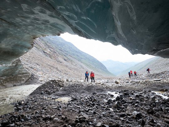 Sur le Similaun et la Wildspitze de notre hôtel à Vent Randonneurs sous une grotte de glace avec vallée rocheuse et rivière en arrière-plan
