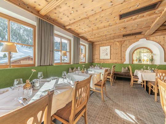 The heights of indulgence in Vent: our restaurant, Die Post Cozy wooden dining area with view of snowy mountains