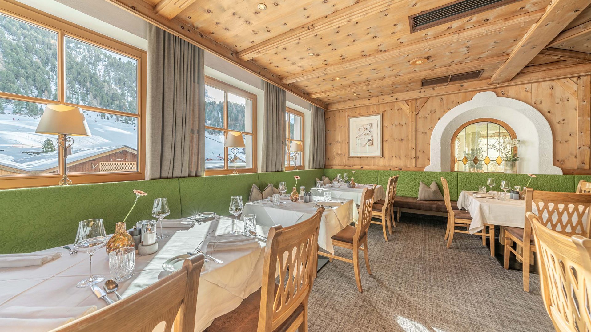 Familienhotel in Vent Gemütlicher Restaurantbereich mit Holzmöbeln und Ausblick auf verschneite Berge