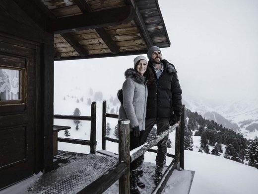 Lieu de rêve Vent : notre hôtel dans l’Ötztal Couple sur le balcon d'un chalet en bois dans la neige avec vue sur la montagne