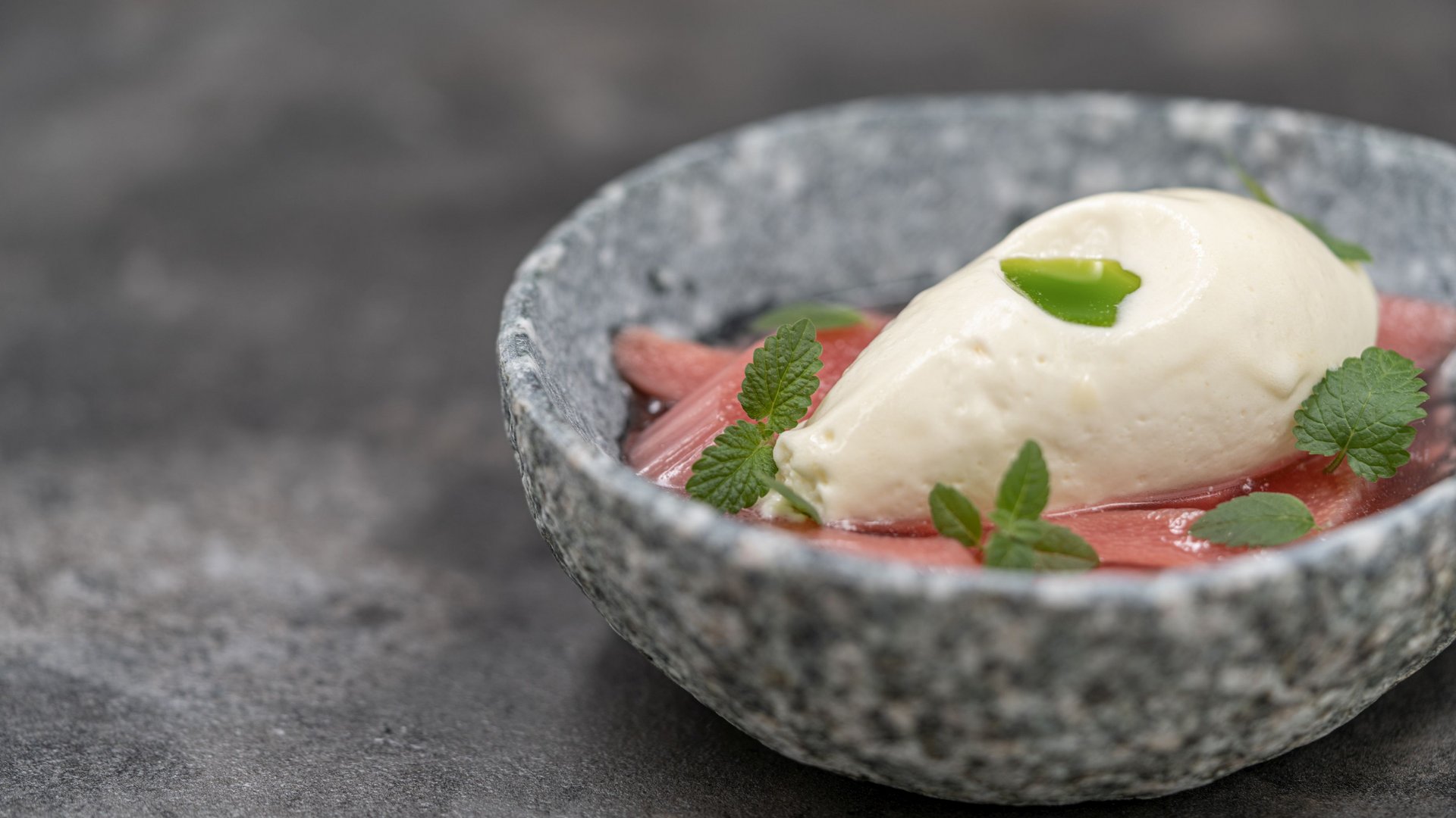 The heights of indulgence in Vent: our restaurant, Die Post Bowl with creamy dessert, red sauce pieces, and fresh green leaves